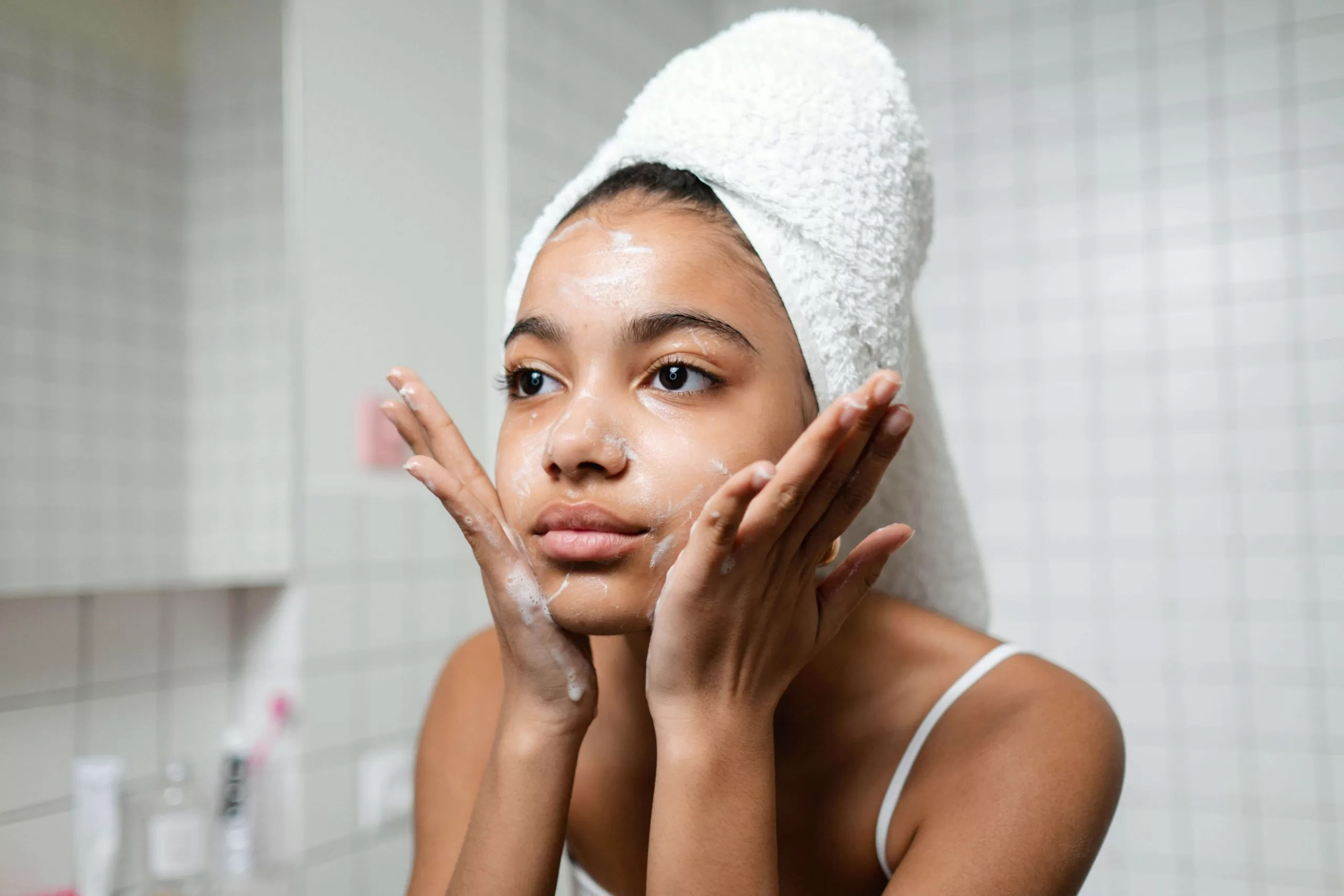 A beautifil young woman does her minimalist skincare routine to achieve a glowing perfect skin